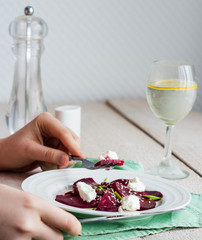 to eat a salad of  beets with goat cheese, oil and sesame, hands