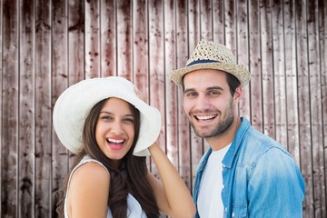 Composite image of happy hipster couple smiling at camera