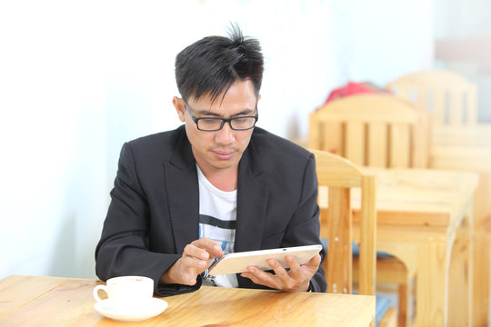 image of a asia businessman use smartphone in a coffee shop