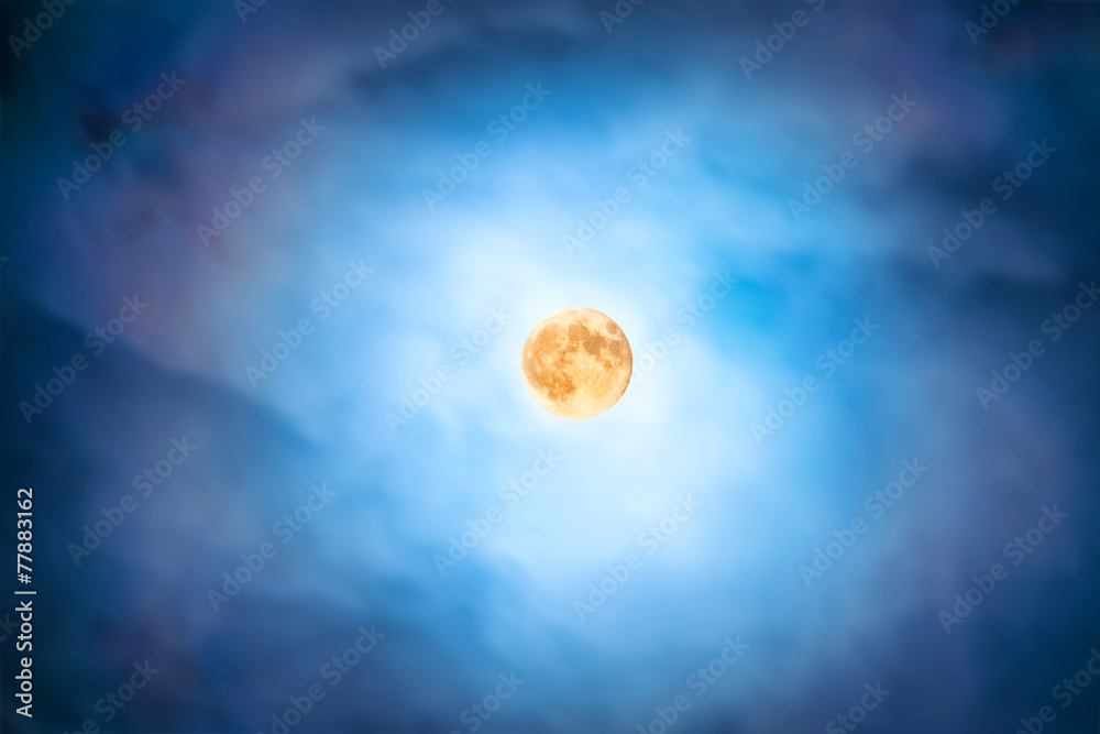 Wall mural night view at the full moon through moving blue clouds