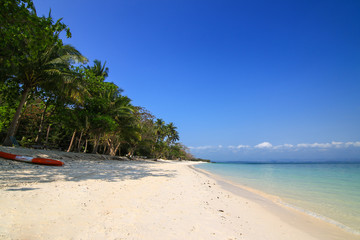 White sand beach, clear water and blue sky at Talu Island