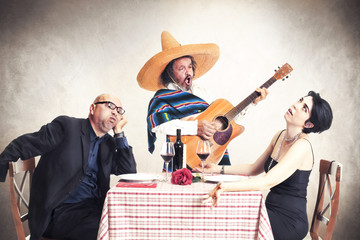 bored couple at dinner oblyed to listen to a mexican musician