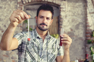 expert oenology measuring the percentage of sugar of the wine