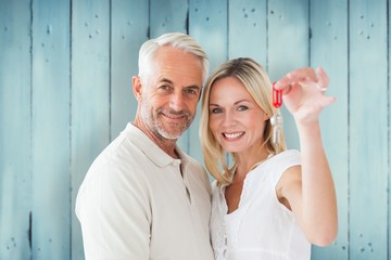 Composite image of happy couple showing their new house key