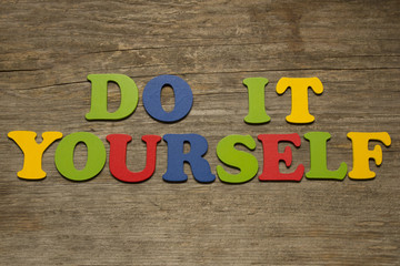 DIY Do It Yourself, words on a wooden background