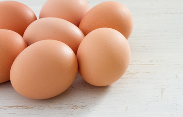 Brown eggs on a white shabby table