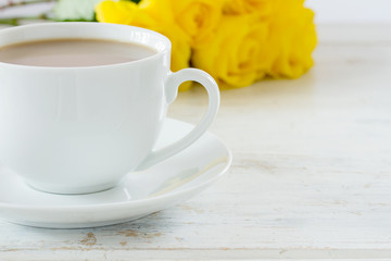 Cup of tea with a bouquet of yellow roses