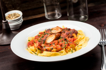 Fototapeta premium Bandnudeln mit Hähnchen und Tomaten Lauch Soße