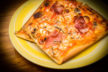 Pizza con prosciutto, funghi, mozzarella e sugo