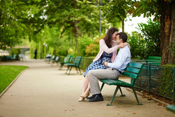 Fototapeta premium Dating couple on a bench in a Parisian park