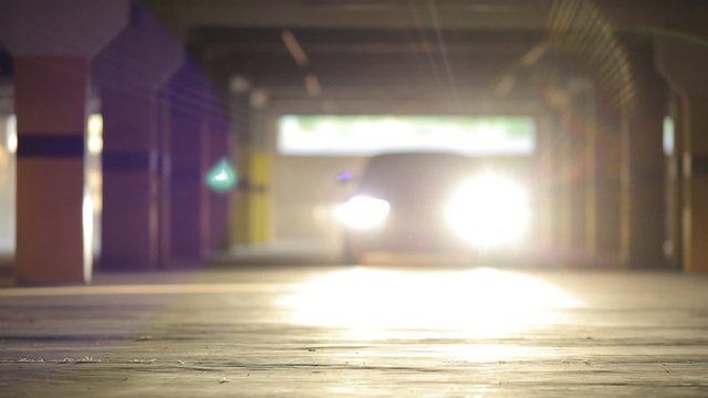 Sports car rides in the parking lot and shining lights into lens