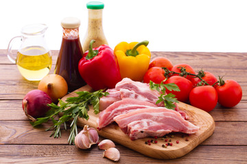 Sliced pieces of raw meat for barbecue with fresh vegetables