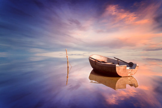Lonely boat and amazing sunset at the sea