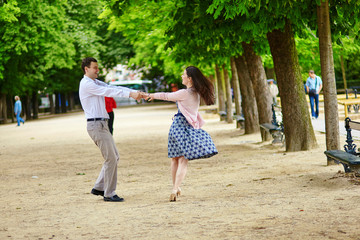 Fototapeta na wymiar Couple dancing in the Luxembourg garden of Paris