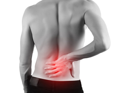 Rear view of a young man holding his back in pain