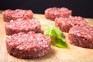 Raw cutlet of minced meat on a wooden cutting board