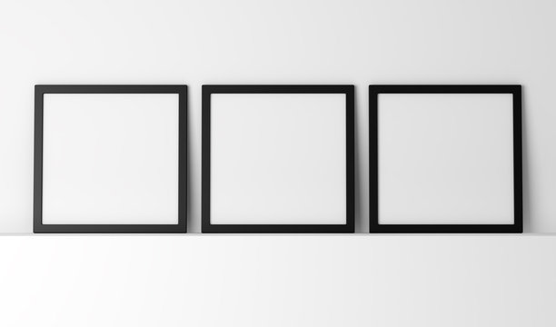 three blank black photo frames on white shelf