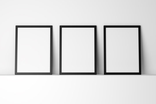 Three Blank Black Photo Frames On White Shelf