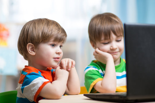 happy children looking at laptop