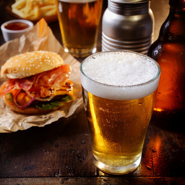 Glass of chilled beer with a hamburger