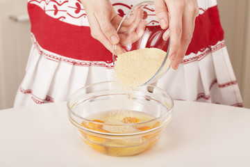 Mixing sugar with eggs