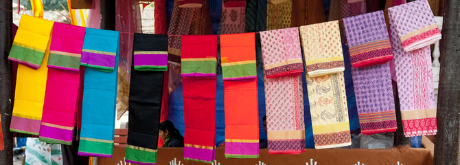 colorful fabrics and shawls at a market stall