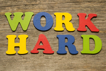 Work Hard text on a wooden background