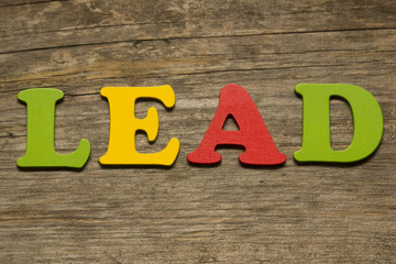 Word lead on a wooden background
