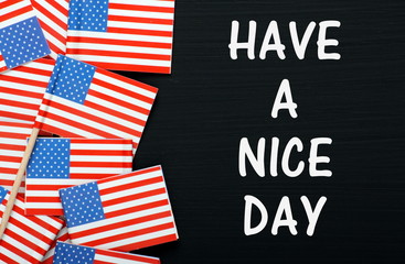 The phrase Have A Nice Day on a blackboard with flags