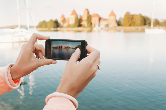 Woman hands with phone taking picture of historical place