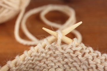 Two bamboo knitting needles in process of knitting