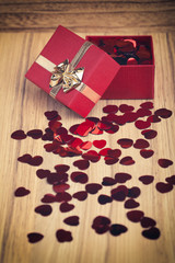 Fototapeta na wymiar Red hearts confetti on wooden background in retro color