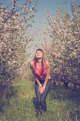 Beautiful woman on the garden with apple trees in a blossom