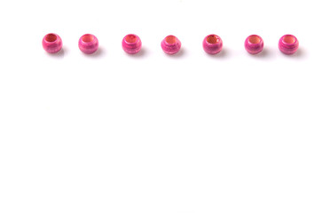 Pink round wooden beads over white background