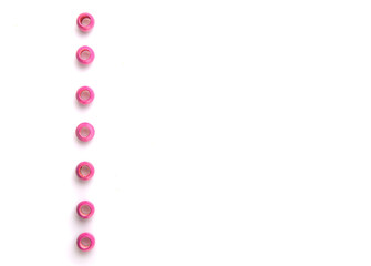 Pink round wooden beads over white background