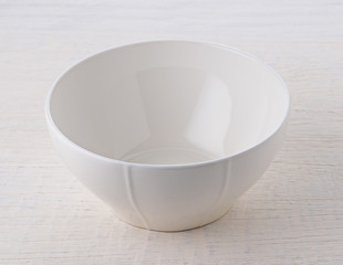 Empty white bowl on wooden table