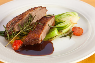 Roasted breast of duck with vegetables.