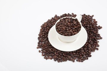 Roasted coffee beans with a cup