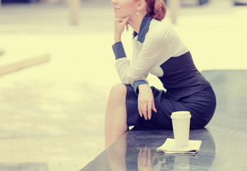 lonely woman sitting outside corporate office