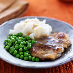 vegan meat alternative fried steak with peas and potatoes