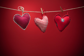 Colorful fabric hearts on red backgrounds