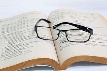 Open book and eyeglasses on desk