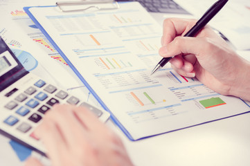 Businessman using calculator analyze report