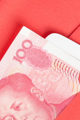 Chinese or 100 Yuan banknotes money in red envelope, as chinese