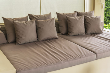 Outdoor patio seating area with big brown sofa and pillows