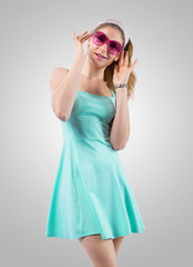 Naklejka premium Smiling young woman looking through rose-coloured spectacles