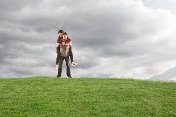 Composite image of man giving girlfriend piggy back