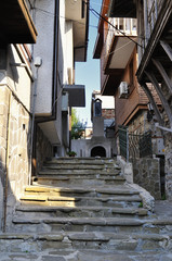 Fototapeta na wymiar Street of old town of Nesebar in Bulgaria with steps leading up