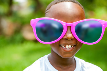 African boy wearing fun extra large sun glasses.