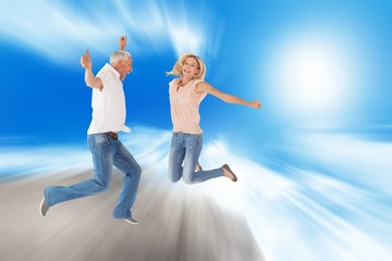 Fototapeta na wymiar Composite image of excited couple cheering and jumping
